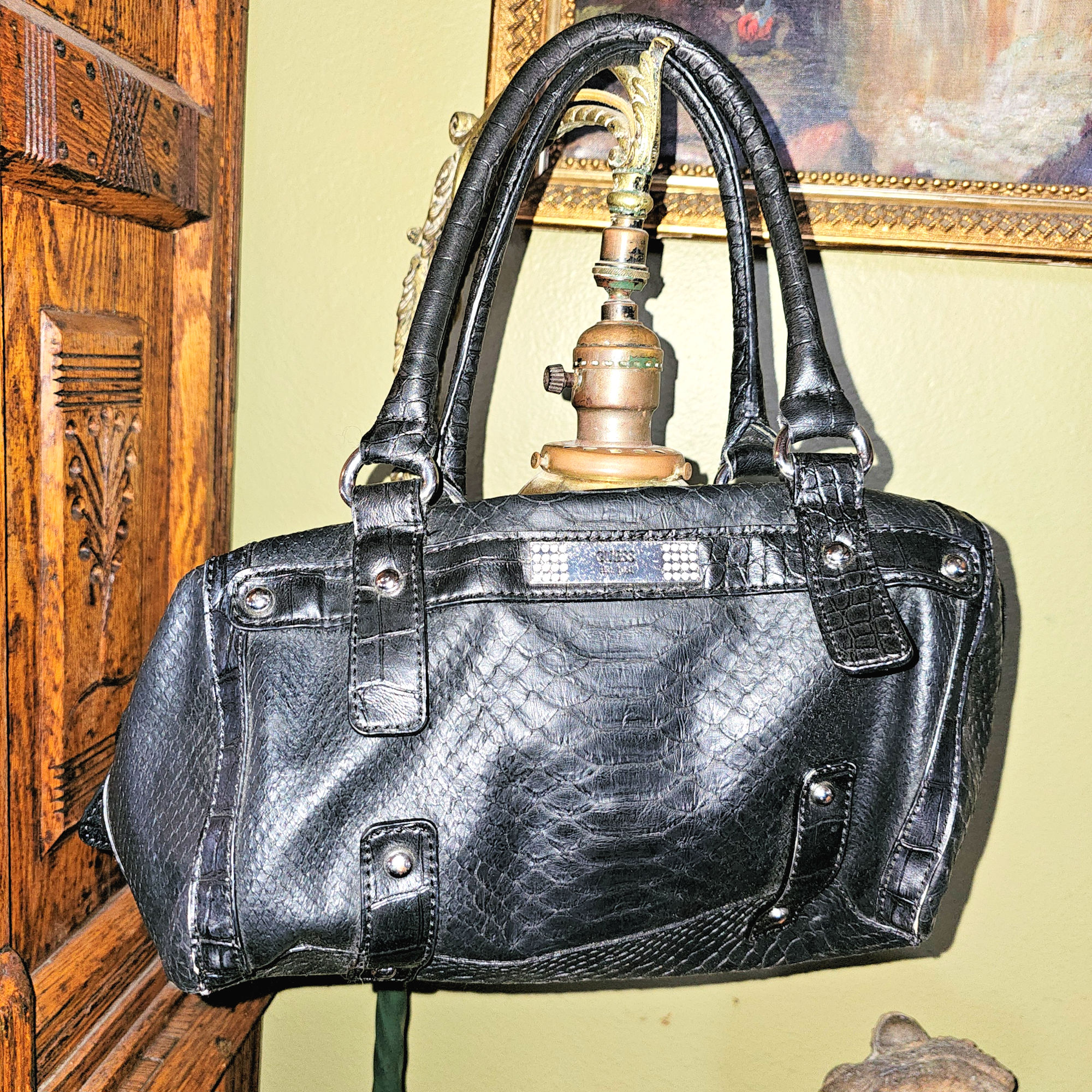 GUESS
                        Snake‑embossed, black faux leather satchel
                        handbag